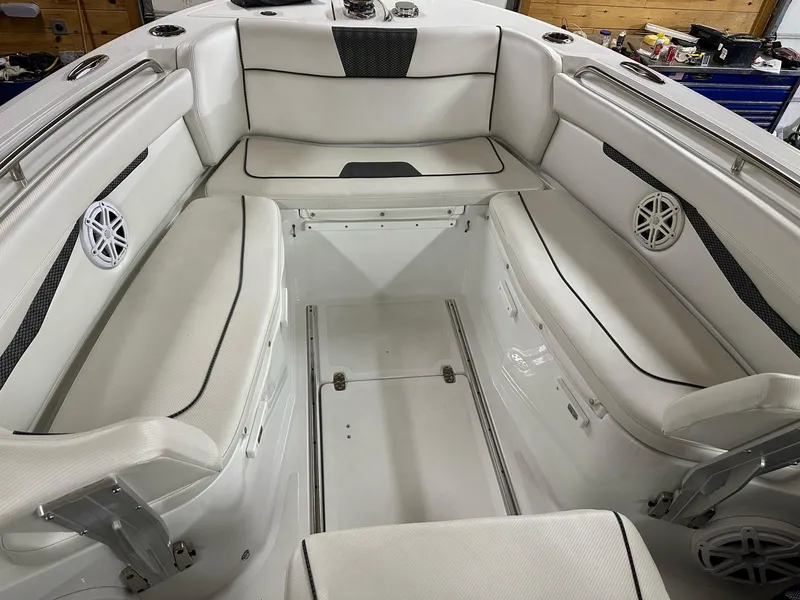 Slide: The Image of 2021 Wellcraft 262 Fisherman boat interior with white cushioned seating and speakers. - 45