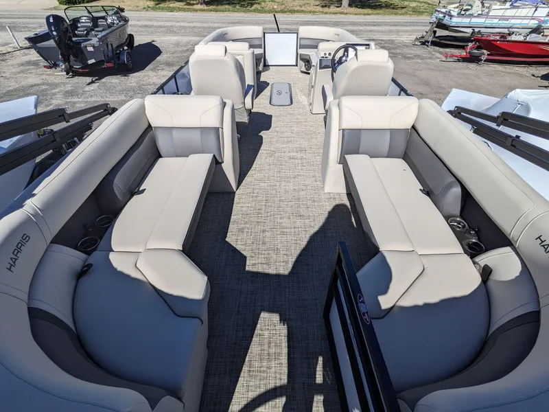 Slide: The Image of 2024 Harris Sunliner 250 pontoon boat with spacious seating and modern interior design. - 2