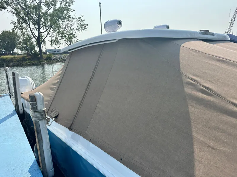 Slide: The Image of 2023 Twin Vee 340 GFX boat with a covered deck, docked by the water. - 13