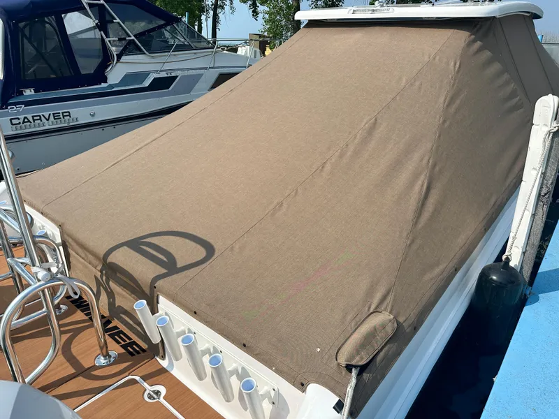 Slide: The Image of 2023 Twin Vee 340 GFX boat with a tan cover docked next to another boat. - 16