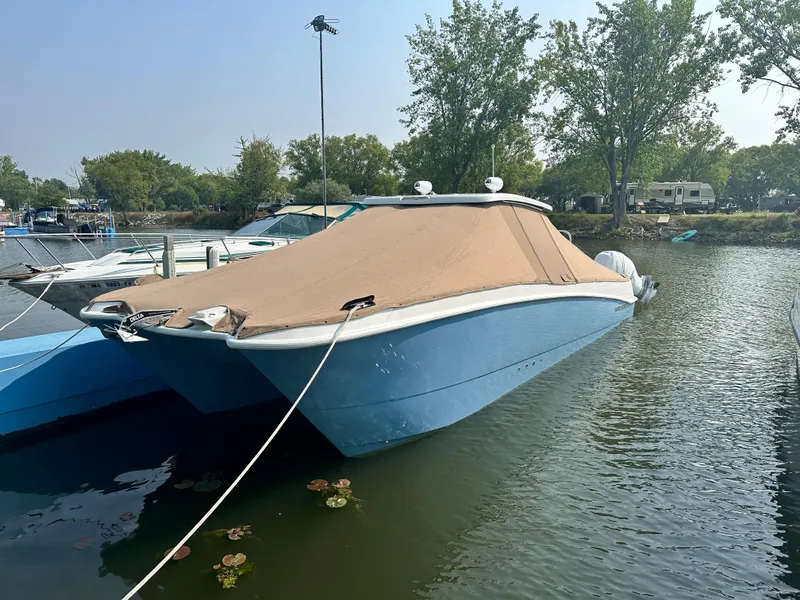 Slide: The Image of 2023 Twin Vee 340 GFX boat docked with cover, in a serene marina. - 17