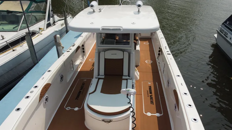 Slide: The Image of 2023 Twin Vee 340 GFX boat docked, showcasing spacious deck and seating area. - 35