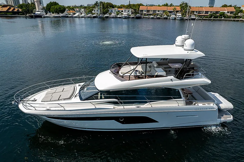 Slide: The Image of 2022 Prestige 520 Fly yacht cruising on a calm waterfront. - 1