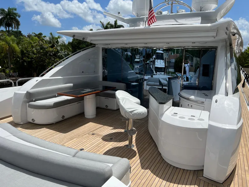 Slide: The Image of 2007 Sunseeker Predator 108 yacht deck with seating and table under a sunny sky. - 12