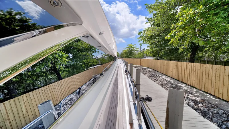 Slide: The Image of 2007 Sunseeker Predator 108 yacht docked beside a wooden fence and lush greenery. - 9