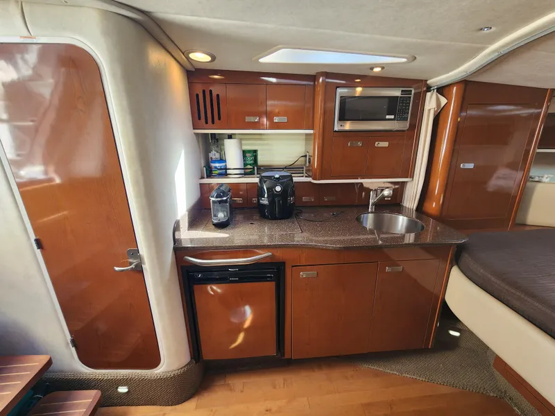 Slide: The Image of Interior of 2012 Sea Ray 350 Sundancer yacht with kitchenette and modern amenities. - 16