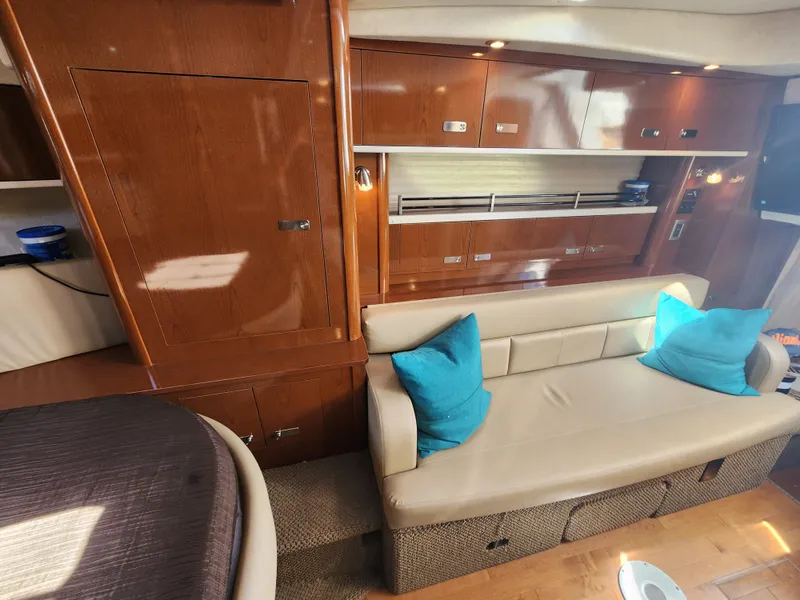 Slide: The Image of Interior of 2012 Sea Ray 350 Sundancer with beige sofa and blue cushions. - 17