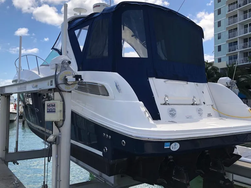 Slide: The Image of 2012 Sea Ray 350 Sundancer yacht docked with blue canopy, clear sky background. - 2