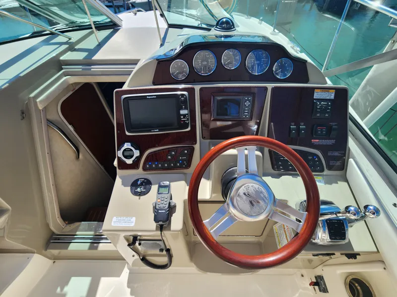 Slide: The Image of Cockpit of 2012 Sea Ray 350 Sundancer with steering wheel and navigation controls. - 3