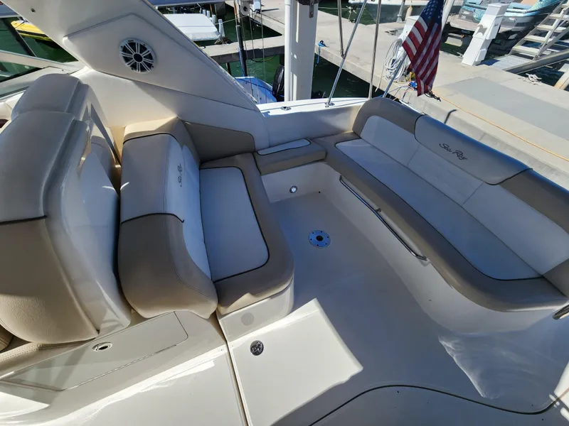 Slide: The Image of 2012 Sea Ray 350 Sundancer boat interior with beige seating and American flag. - 5