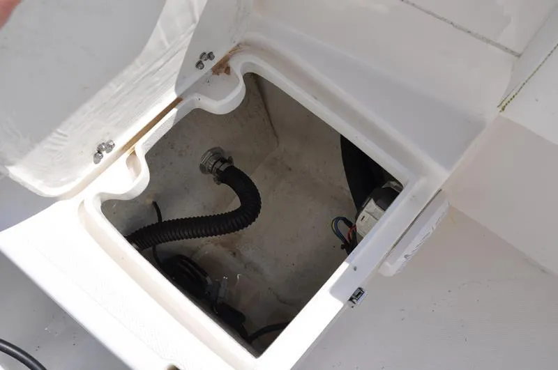 Slide: The Image of Open storage compartment in 2021 Century Coronado boat showing wiring and hose. - 11