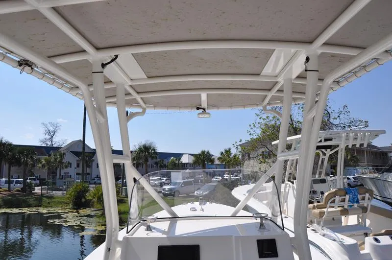 Slide: The Image of 2021 Century Coronado boat with canopy and windshield docked near waterfront homes. - 8