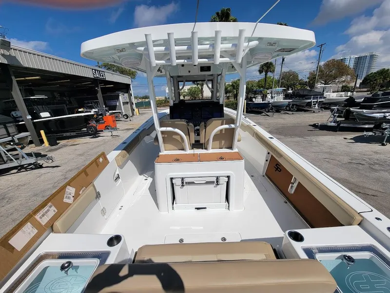 Slide: The Image of 2025 Sea Pro 322 DLX boat interior at a dealership, showcasing seating and console. - 13