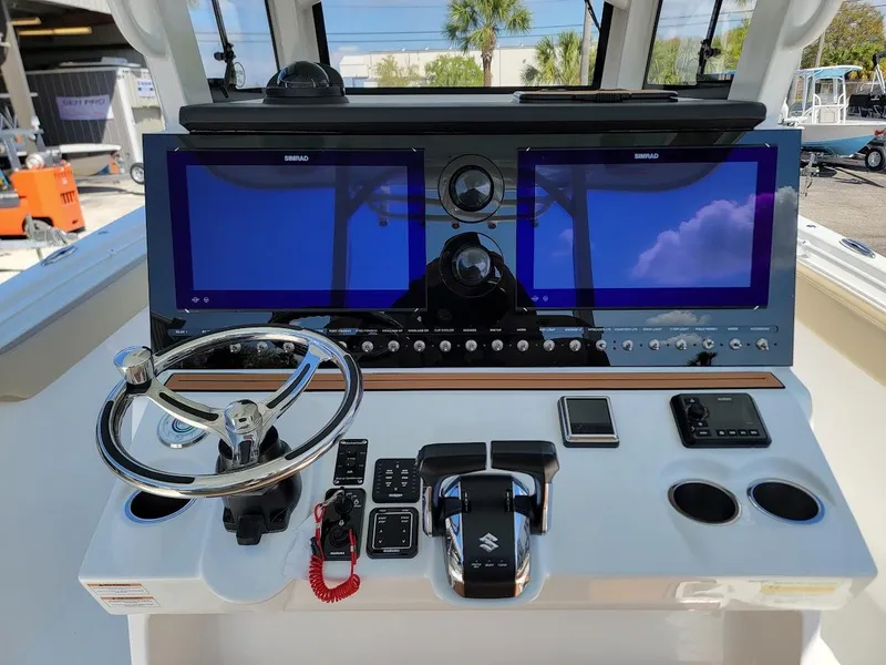 Slide: The Image of 2025 Sea Pro 322 DLX boat dashboard with dual Simrad displays and Suzuki controls. - 16
