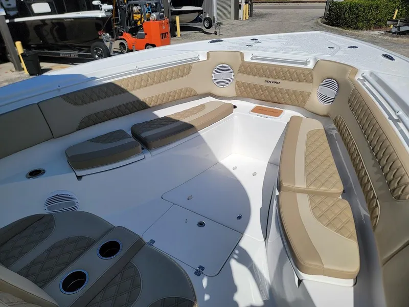 Slide: The Image of 2025 Sea Pro 322 DLX boat interior with cushioned seating and cup holders. - 22
