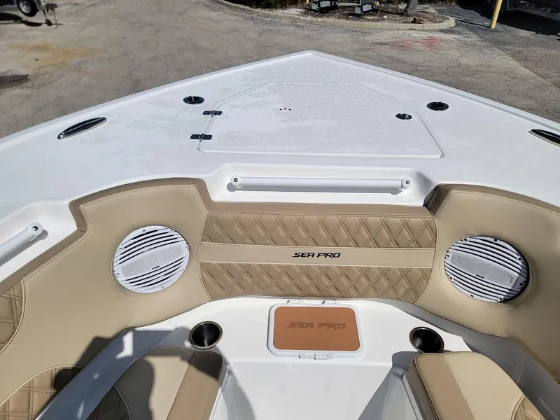 Slide: The Image of 2025 Sea Pro 322 DLX boat interior with beige seating and built-in speakers. - 23