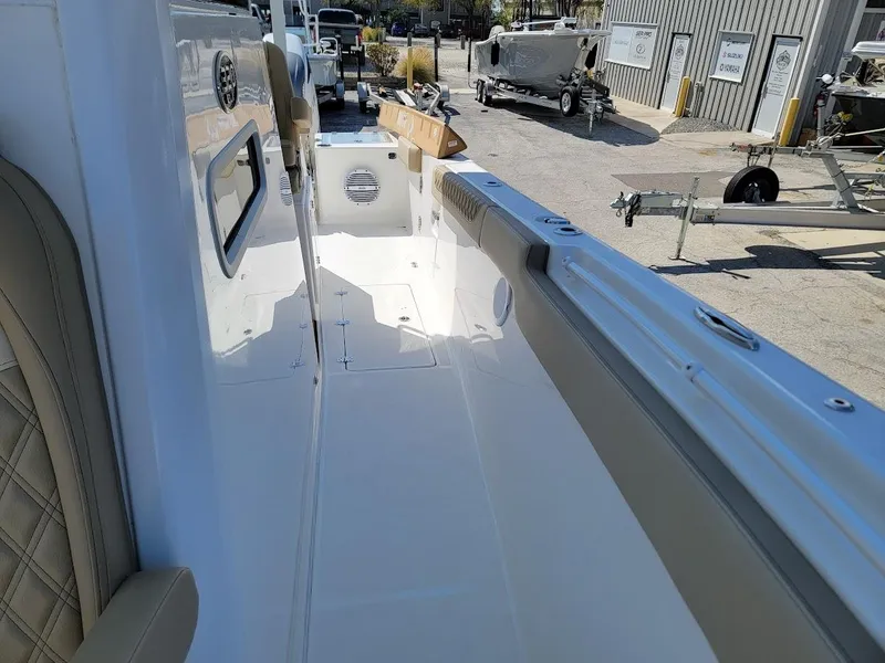 Slide: The Image of 2025 Sea Pro 322 DLX boat interior, white deck, beige seating, docked at marina. - 28