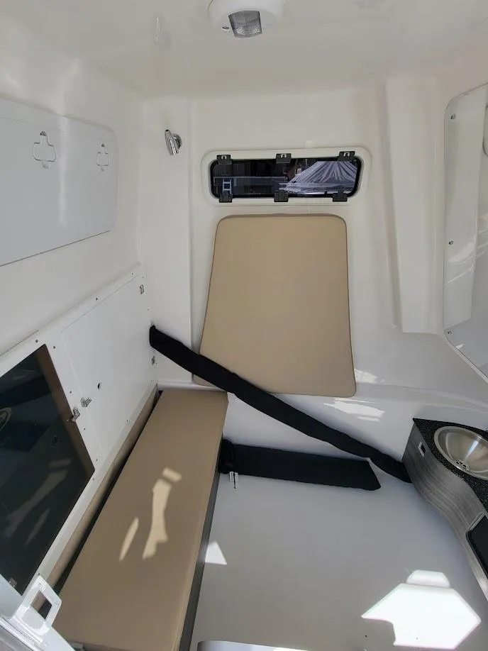 Slide: The Image of Interior cabin of 2025 Sea Pro 322 DLX boat with beige seating and window. - 31
