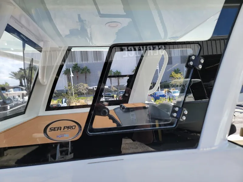 Slide: The Image of 2025 Sea Pro 322 DLX boat interior with open window and steering wheel. - 36