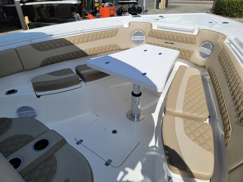 Slide: The Image of 2025 Sea Pro 322 DLX boat interior with cushioned seating and table. - 38