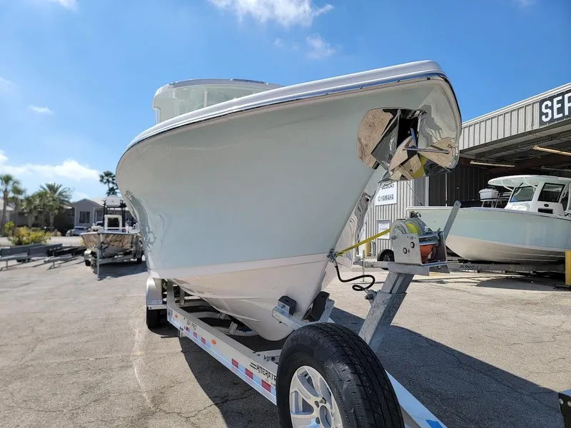 Slide: The Image of 2025 Sea Pro 322 DLX boat on a trailer at a marina under a clear blue sky. - 5