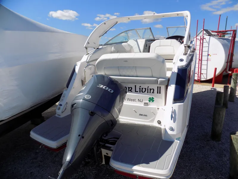 Slide: The Image of 2019 Regal 26XO boat with outboard motor, docked under clear blue sky. - 13