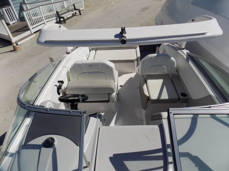 Slide: The Image of 2019 Regal 26XO boat interior with seating and helm, docked outdoors. - 6