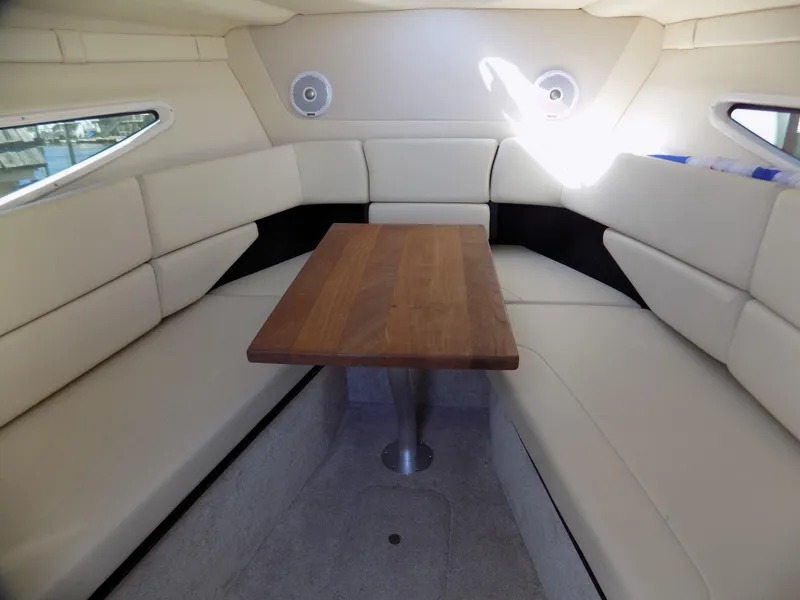 Slide: The Image of Interior of 2019 Regal 26XO boat with cushioned seating and wooden table. - 9