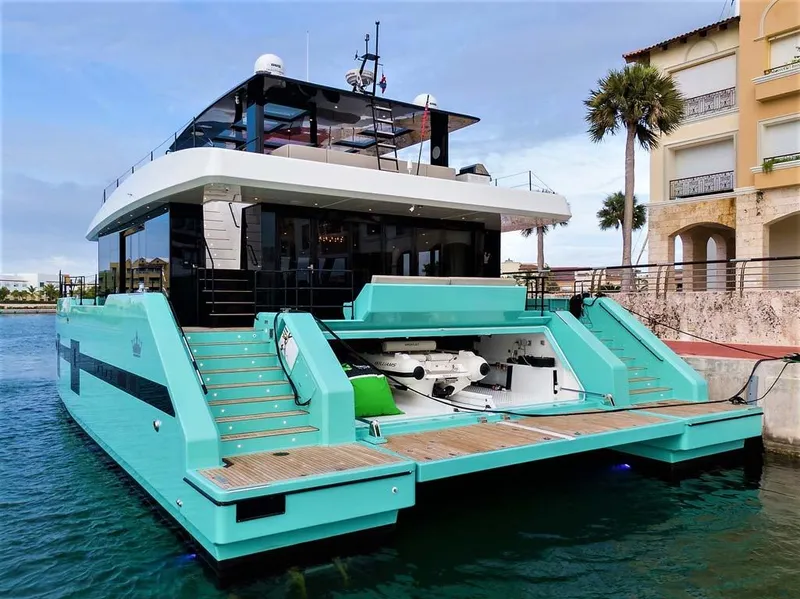 Slide: The Image of Luxurious 2018 Sunreef 68 Supreme yacht docked, featuring sleek design and vibrant turquoise color. - 2