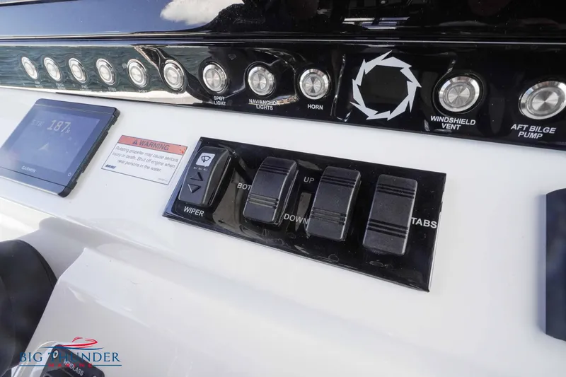 Slide: The Image of Control panel of a 2023 Fountain 38 TE boat with switches and display. - 36