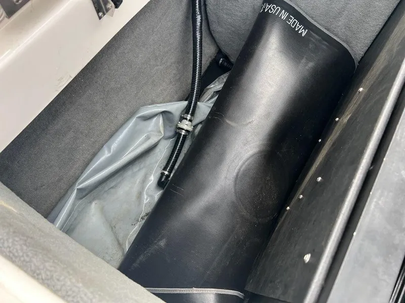 Slide: The Image of 2014 Moomba Mojo 2.5 ballast system compartment with black hose and bag. - 10