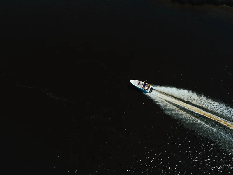 Slide: The Image of 2026 Key West 189 FS boat interior with seating and console, parked in a marina. - 13