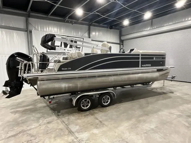 Slide: The Image of 2023 Harris Cruiser 230 pontoon boat in a warehouse, on a trailer. - 8