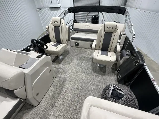 Slide: The Image of 2023 Harris Cruiser 230 interior with plush seating and modern dashboard in a showroom. - 9