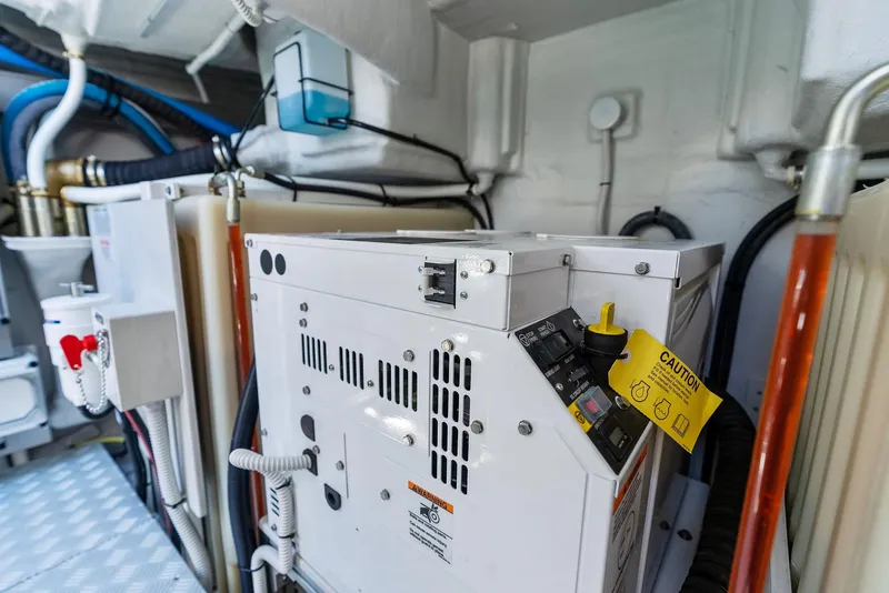 Slide: The Image of Engine room of 2022 Riva 38 Rivamare with electrical equipment and caution tag. - 39