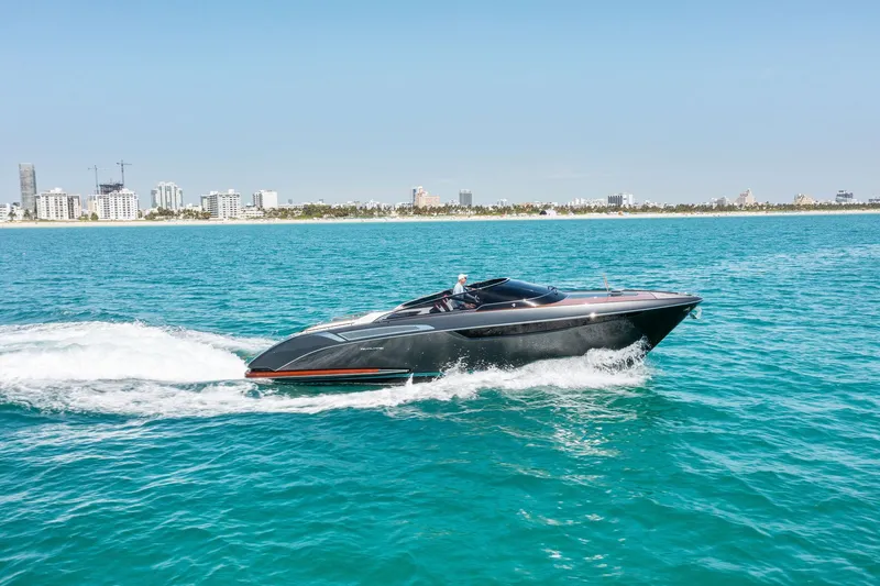 Slide: The Image of 2022 Riva 38 Rivamare luxury yacht cruising on blue ocean near city skyline. - 9