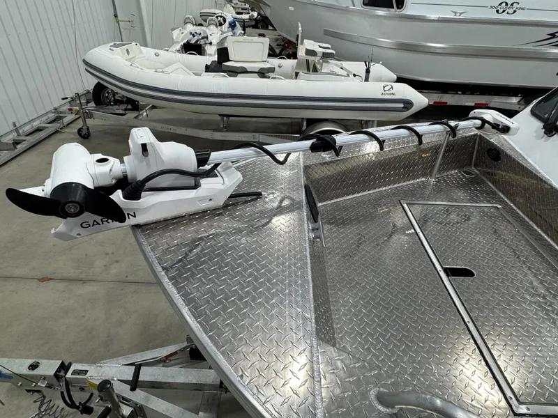Slide: The Image of 2023 Weldcraft 210 Revolution boat with Garmin trolling motor, diamond plate deck, and trailer. - 1