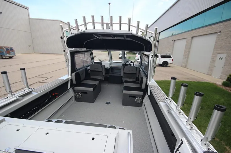 Slide: The Image of 2023 Weldcraft 210 Revolution F200XB Walleye Edition boat interior, spacious seating, and rod holders. - 10