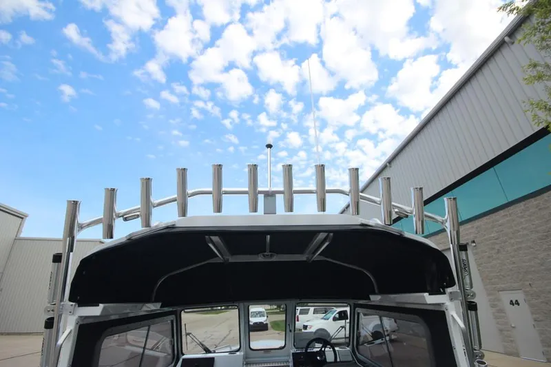 Slide: The Image of 2023 Weldcraft 210 Revolution F200XB Walleye Edition boat exterior with rod holders. - 12