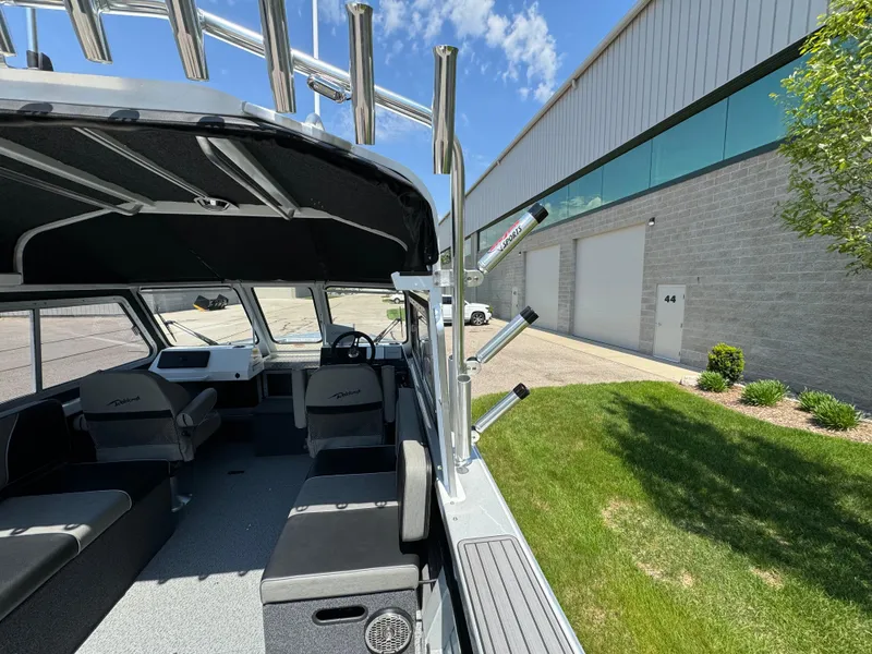 Slide: The Image of 2023 Weldcraft 210 Revolution F200XB Walleye Edition boat interior near warehouse. - 13