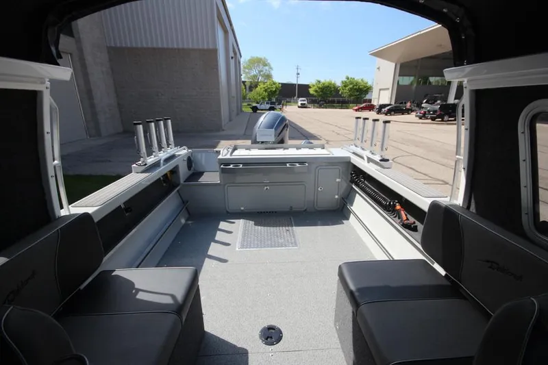 Slide: The Image of 2023 Weldcraft 210 Revolution F200XB Walleye Edition boat interior, spacious seating, and fishing rod holders. - 15
