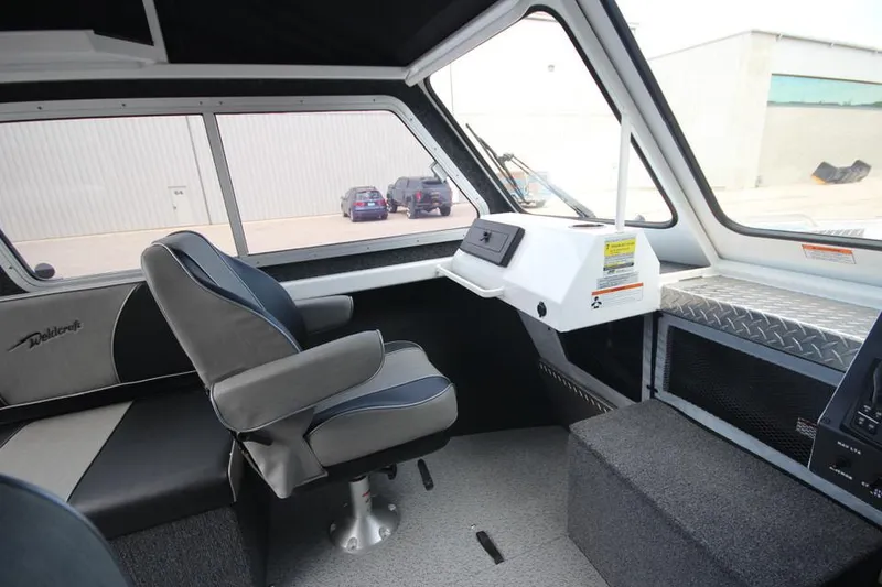 Slide: The Image of 2023 Weldcraft 210 Revolution F200XB Walleye Edition boat interior with captain's chair and dashboard. - 32