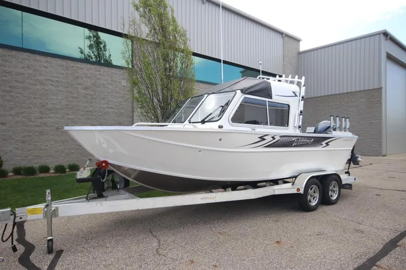 Slide: The Image of 2023 Weldcraft 210 Revolution F200XB Walleye Edition boat on trailer outside industrial building. - 4