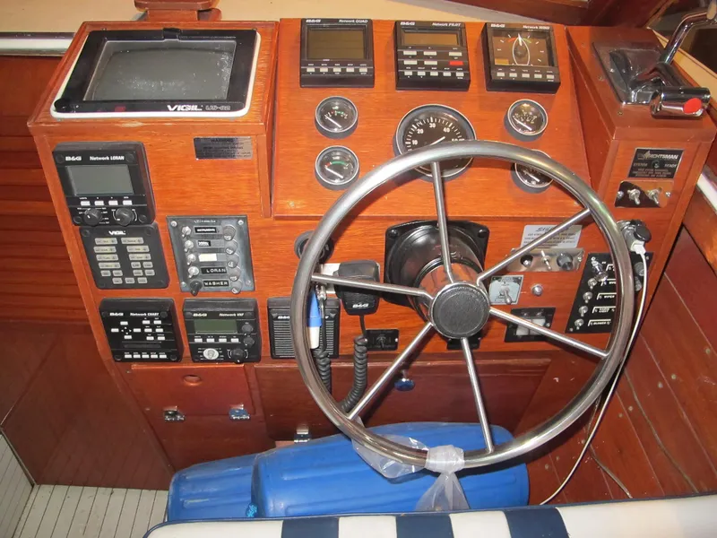 Slide: The Image of Skiff Craft 26 1990 boat dashboard with steering wheel and navigation instruments. - 11