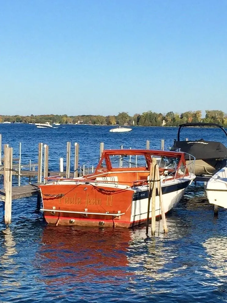 Slide: The Image of 1990 Skiff Craft 26 boat docked on a sunny lake. - 2