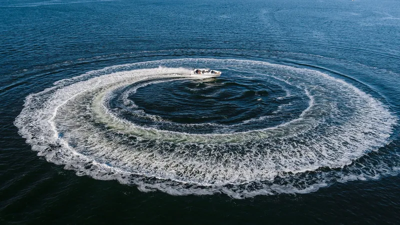 Slide: The Image of Nimbus Tender 9 (2025) creating circular wake pattern on open water. - 14