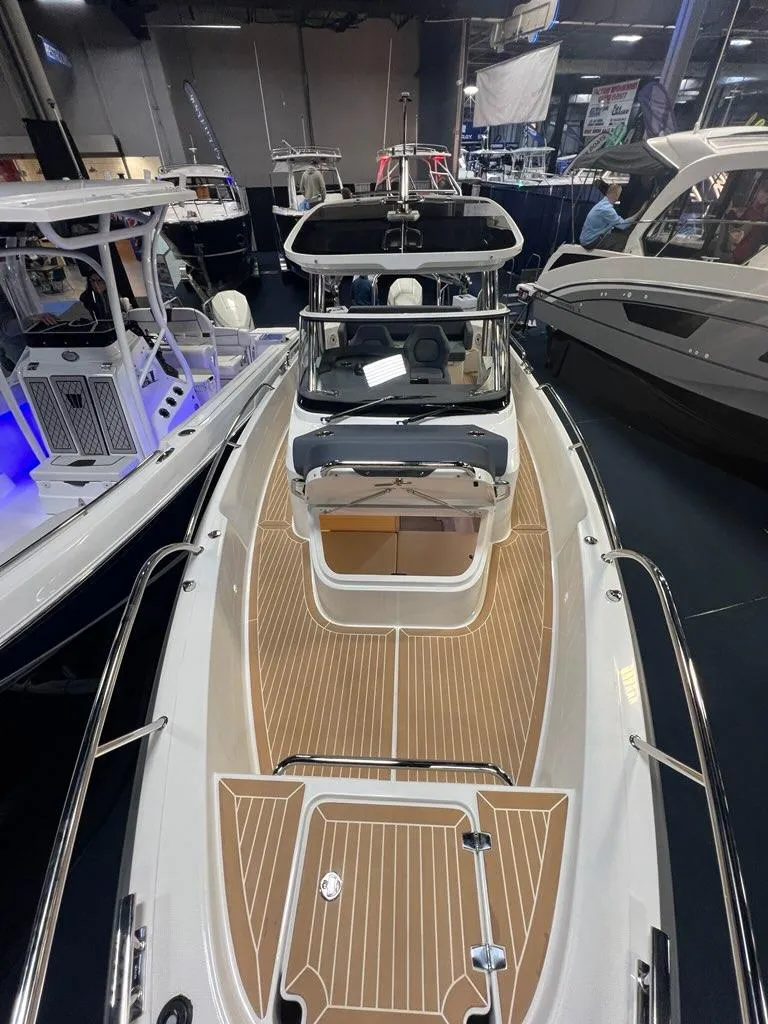 Slide: The Image of 2025 Nimbus Tender 8 boat with sleek design and wooden deck, showcased indoors. - 8