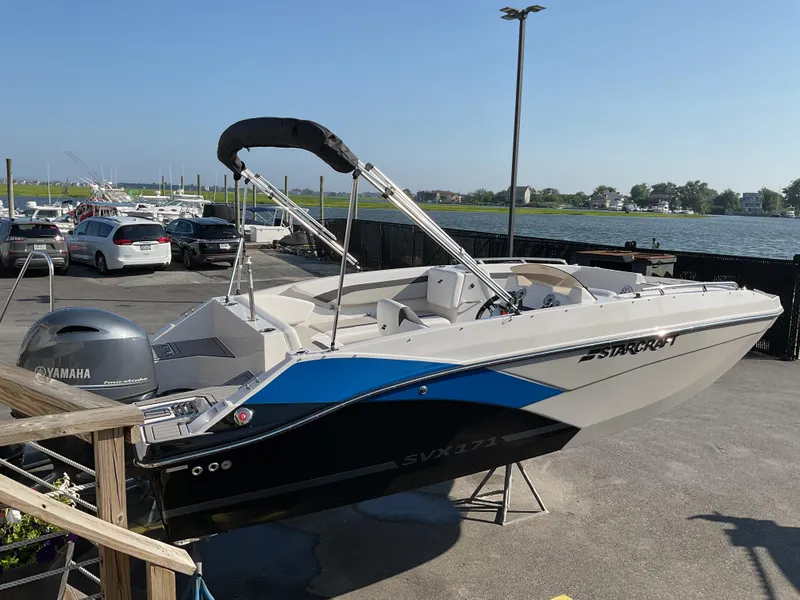 Slide: The Image of 2023 Starcraft 171 SVX boat with Yamaha engine, docked near waterfront. - 2