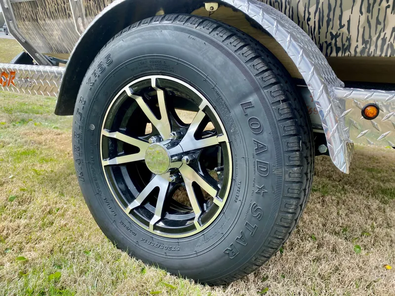 Slide: The Image of 2023 Thor Lake Hammer trailer wheel with Load Star tire on grass. - 10