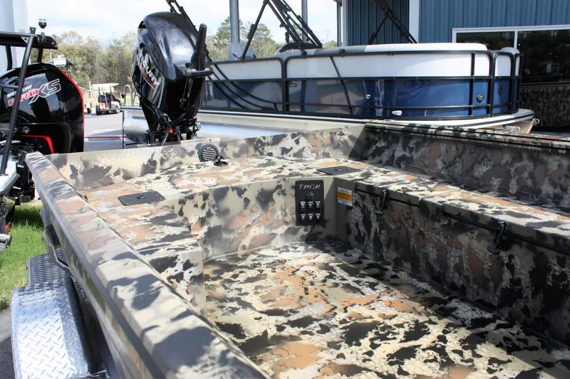 Slide: The Image of 2023 Thor Lake Hammer boat with camouflage interior and outboard motor. - 2